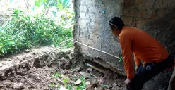 Petugas BPBD Kota Bogor mengecek kondisi rumah yang rusak akibat tanah ambles di Kampung Margabakti, Kelurahan Kertamaya, Kecamatan Bogor Selatan. (Sumber: Dok. BPBD Kota Bogor)