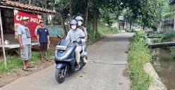 Pengendara melintas di Jalan Enggram, Kelurahan Sawangan Baru, Kota Depok, Rabu, 6 Agustus 2025. (Sumber: POSKOTA | Foto: Angga Pahlevi)