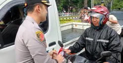 Kapolres Bogor AKBP Wikha Ardilestanto membagikan bendera merah putih kepada pengendara sepeda motor di Jalan Tegar Beriman, Cibinong, Kabupaten Bogor. (Sumber: POSKOTA | Foto: Giffar Rivana)