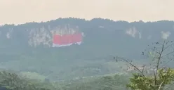 Pemasangan bendera merah putih berukuran 50x80 meter di Tebing Jeger, Klapanunggal, Kabupaten Bogor, memecahkan rekor MURI. (Sumber: Pemkab Bogor)