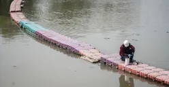 Petugas menyemprotkan air saat simulasi penanganan busa di Pintu Air Weir 3 Marunda, Kanal Banjir Timur (KBT), Jakarta Utara, Rabu, 13 Agustus 2025. (Sumber: Poskota/Bilal Nugraha Ginanjar)