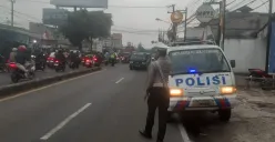 Petugas Polsek Bojongsari menempatkan kendaraan patroli dengan rotator biru menyala di jalur yang kerap dilalui pemotor melawan arus di Jalan Raya Parung–Ciputat, Kecamatan Bojongsari. (Sumber: Poskota/Angga Pahlevi)
