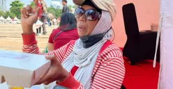 Sartika, 52 tahun, warga asal Tanggerang datang ke Monas, Jakarta Puat, untuk merasakan peringatan HUT ke-80 RI, Minggu, 17 Agustus 2025. (Sumber: Poskota/Muhammad Tegar Jihad)