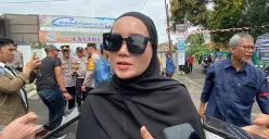 Orang tua murid, Hera 36 tahun, mengikuti aksi protes di depan gedung yayasan SDIT Raudlatul Jannah, Jalan Veteran III, Kecamatan Ciawi, Kabupaten Bogor, Selasa, 19 Agustus 2025. (Sumber: Poskota/Giffar Rivana)