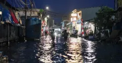 Warga melintasi genangan rob di Muara Angke, Jakarta Utara, Senin, 18 Agustus 2025. (Sumber: Poskota/Bilal Nugraha Ginanjar)