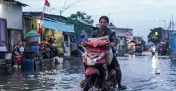 Ilustrasi - Warga melintasi genangan rob di Muara Angke, Jakarta Utara, Senin, 18 Agustus 2025. (Sumber: Poskota/Bilal Nugraha Ginanjar)