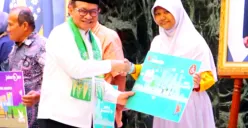 Potret Gubernur DKI Jakarta, Pramono Anung (kiri) yang memberikan secara simbolis kartu rekening untuk penerima baru bansos Kartu Anak Jakarta (KAJ). (Sumber: Dinas Sosial Pemprov DKI Jakarta)