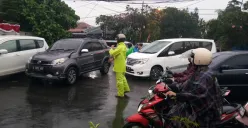 Ilustrasi - Polisi mengatur arus lalu lintas yang macet saat hujan deras. (Sumber: Polsek Cinere)