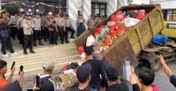 Pendemo saat menumpahkan sampah dari dump truk di depan Kantor Bupati Pandeglang pada Rabu, 20 Agustus 2025. (Sumber: POSKOTA | Foto: Samsul Fatoni)