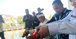 Wali Kota Bekasi, Tri Adhianto bersama Gubernur Jawa Barat, Dedi Mulyadi menuangkan air kendi sebagai simbol peletakan batu pertama pembangunan wisata air di Kalimalang, Kamis, 21 Agustus 2025. (Sumber: POSKOTA | Foto: Nurpini Aulia Rapika)