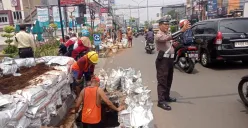 Petugas kepolisian mengatur lalu lintas di Jalan Kartini, Depok, saat proyek galian kabel menyebabkan kemacetan dan menyempitkan ruas jalan. (Sumber: Poskota/Angga Pahlevi)