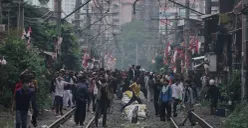 Sejumlah massa berkerumun di tengah rel kereta api, Jakarta, Senin, 25 Agustus 2025. (Sumber: Poskota/Bilal Nugraha Ginanjar)