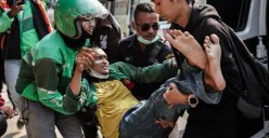 Seorang massa aksi beratribut ojek online (ojol) digotong saat demonstrasi di Satuan Brimob Polda Metro Jaya, Kecamatan Senen, Jakarta Pusat, Jumat, 29 Agustus 2025. (Sumber: Poskota/Bilal Nugraha Ginanjar)