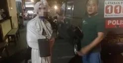 Polisi mengamankan remaja pengamen berkostum menyerupai pocong yang telah membuat resah masyarakat. (Sumber: Poskota/Angga Pahlevi)