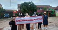 Orang tua murid bentangkan spanduk di SDN Pajeleran 01 buntut diskriminasi yang diterima anaknya oleh oknum guru. (Sumber: Poskota | Foto: Giffar Rivana)