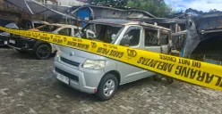 Kondisi terkini bangunan kantor rental dan bengkel oli terbakar. Terlihat sisa bangkai empat unit mobil rental dan satu motor yang terbakar dan dipasang garis polisi. (Sumber: Poskota/Angga Pahlevi)