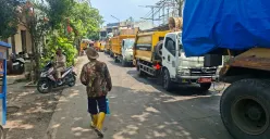 Antrean kendaraan pengangkut sampah mengular di Jalan TPA Jalan Baru, Cipayung, Kota Depok, Selasa, 23 Desember 2025, akibat keterbatasan akses masuk dan pemeliharaan fasilitas di TPA Cipayung. (Sumber: Poskota/Angga Pahlevi)