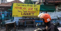 Spanduk penolakan uang ganti rugi proyek Tol Semanan-Sunter terpasang di permukiman RW 09 dan RW 12 Duri Pulo, Jakarta Pusat. (Sumber: POSKOTA | Foto: Dhiya Ahmad Fauzan/M2)
