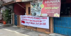 Warga RW 09 dan RW 12 Duri Pulo membentangkan spanduk penolakan ganti rugi proyek Tol Semanan–Sunter saat menyuarakan keberatan di kawasan Duri Pulo, Jakarta Pusat. (Sumber: Poskota/M. Tegar Jihad)