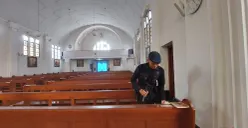 Tim Jibom Brimob Polda Jabar memastikan tidak ada benda mencurigakan, termasuk di area mimbar yang akan digunakan pastor saat memimpin Misa Natal dan ibadah pada 25 Desember 2025. (Sumber: Poskota | Foto: Gatot Poedji Utomo)