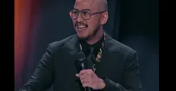 Pandji Pragiwaksono saat membawakan special stand-up comedy Mens Rea, sebuah pertunjukan tanpa sensor yang menggabungkan humor dan refleksi kritis tentang politik dan niat di balik kekuasaan. (Sumber: Dok/Netflix)