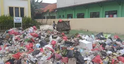Tumpukan sampah rumah tangga menggunung di halaman Kantor Kelurahan Kebalen, Kecamatan Babelan, Kabupaten Bekasi, Senin 29 Desember 2025. (Sumber: Poskota/Nurpini Aulia Rapika.)