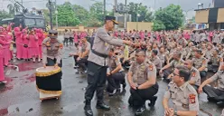 Kapolres Metro Depok, Kombes Pol Abdul Waras melakukan tradisi siram air kembang kepada personel yang naik pangkat di Mapolres Metro Depok, Rabu, 31 Desember 2025. (Sumber: Poskota/Angga Pahlevi)