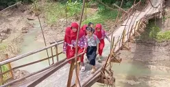 Sejumlah anak-anak SD di Desa Nanggala, Kecamatan Cikeusik, Kabupaten Pandeglang, saat melintas jembatan gantung yang nyaris putus. (Sumber: Dok. Warga)