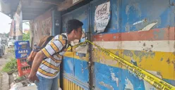 Seorang warga saat melihat kondisi warung kelontong tempat ditemukannya jasad lansia di Cabangbungin, Kabupaten Bekasi, Senin, 10 Februari 2025. (Sumber: Poskota/Ihsan Fahmi)