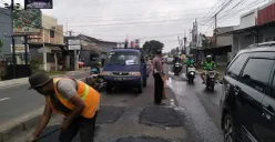 Kanitlantas Polsek Bojongsari, Iptu Suwardi melakukan penjagaan di lokasi penambalan jalan rusak di Jalan Raya Ciputat-Parung, Bojongsari Baru, Bojongsari, Kota Depok. (Sumber: Dok. Satlantas Polsek Bojongsari)