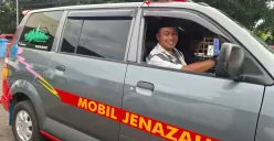 Deni Alik atau yang biasa disapa Ali, warga Cilodong, Depok, saat mengendarai mobil Jenazah, Kamis (20/2). Dia membantu banyak orang dengan menjadi pengemudi mobil jenazah sejak 1995. (Sumber: Poskota/Angga Pahlevi)