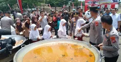 Kapolda Banten Irjen Suyudi Ario Seto menuangkan soto tangkar ke dalam boks nasi yang dibawa masing-masing murid SD, di halaman Mapolres Serang, Jumat, 21 Februari 2025. (Sumber: Poskota/Rahmat Haryono)