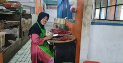 Sri, pedagang sayur mayur di Pasar Slipi, Jakarta Barat, saat tengah memilah cabai, Kamis, 2 Januari 2025. (Sumber: Poskota/Pandi)