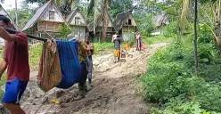 Sejumlah warga di Desa Tanjungan, Kecamatan Cikeusik, Kabupaten Pandeglang, Provinsi Banten menandu pasien ibu hamil yang hendak melahirkan karena kondisi jalan rusak parah. (Sumber: Tangkapan layar video warga)