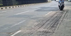 Pengendara motor terlihat hati-hati saat melintas di jalan Ahmad Yani, Kota  Bekasi dengan kondisi hamparan pasir dan penambalan lubang jalan. Sabtu, 11 Desember 2025. (Sumber: Poskota/Ihsan)