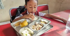 Gibran Hafiz Nurdiansyah, 7 tahun, siswa SDN Lengkong Gudang, Kota Tangsel saat menyantap menu MBG. (Sumber: Poskota/Veronica Prasetio)