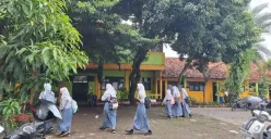 Sejumlah siswa SMAN 20 Kota Bekasi saat hendak masuk ke kelas mereka di SMP YPII Bungur di Jalan Raya Seroja, Kampung Ceger, Harapan Jaya, Bekasi Utara, Kota Bekasi. Kamis, 23 Januari 2025. (Sumber: Poskota/Ihsan Fahmi)