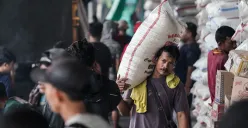 Ilustrasi - Seorang pekerja mengangkut satu karung beras di Pasar Induk Beras Cipinang, Jakarta Timur, Minggu, 29 Juni 2025. (Sumber: Poskota/Bilal Nugraha Ginanjar)