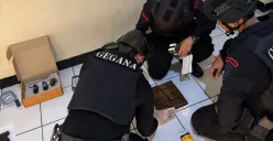 Detasemen Gegana Brimob Mabes Polri memeriksa senjata dan peluru dari koper WNA FIlipina yang menggemparkan warga Pasar Minggu, Jakarta Selatan. (Sumber: Polsek Pasar Minggu)