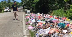 Warga mengamati tumpukan sampah di Jalan Raya Sobang-Ciseket, Desa Mekarsari, Kecamatan Panimbang, Pandeglang. (Sumber: POSKOTA | Foto: Samsul Fatoni)