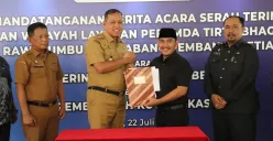 Bupati Bekasi Ade Kuswara Kunang dan Walikota Bekasi Tri Adhianto menandatangani berita acara serah terima aset dan layanan Perumda Tirta Bhagasasi Cabang Rawalumbu dan Cabang Pembantu Setia Mekar, di Pemkot Bekasi. (Sumber: Dok. Pemkab Bekasi)