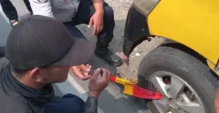 Petugas mengunci ban mobil dalam penertiban di kawasan Padalarang, Kabupaten Bandung Barat, Rabu, 23 Juli 2025. (Sumber: Poskota/Gatot Poedji Utomo)