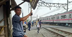 Khadafi saat menjaga perlintasan rel kereta liar di Perumahan Gaperi, Bojonggede, Sabtu sore, 26 Juli 2025. (Sumber: POSKOTA | Foto: Angga Pahlevi)