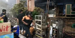 Sejumlah pedagang hanya bisa menyelamatkan sedikit aset mereka saat kebakaran hebat terjadi di Pasar Taman Puring, Jakarta, pada Senin, 28 Juli 2025. (Sumber: POSKOTA | Foto: Ali Mansur)
