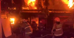 Petugas Damkar berupaya memadamkan api yang membakar sejumlah bangunan di Pasar Taman Puring di Kebayoran Baru, Jakarta Selatan, pada Senin petang, 28 Juli 2025, sekitar pukul 18.00 WIB. (Sumber: POSKOTA | Foto: Ali Mansur)