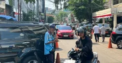 Salah seorang petugas parkir saat membantu pengendara mengeluarkan motornya di Jalan Palatehan I, Kebayoran Baru, Jakarta Selatan, Kamis, 31 Juli 2025. (Sumber: Poskota/Muhammad Tegar Jihad)