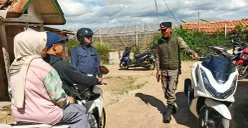 Petugas mengarahkan pengendara motor yang hendak melintas di kawasan tanah bergerak di Desa Cimanggu, Kecamatan Ngamprah, Bandung Barat pada Kamis, 31 Juli 2025. (Sumber: POSKOTA | Foto: Gatot Poedji Utomo)