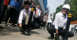 Wali Kota Cimahi, Ngatiyana (kanan), dan Wakil Wali Kota, Adithiya Yudhistira (kiri), memasang tiang pembatas di kawasan Alun-alun timur, Jalan Ria, Senin 2 Juni 2025. (Sumber: POSKOTA | Foto: Gatot Poedji Utomo)