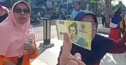 Seorang warga berhasil mendapatkan uang yang disebar dari atas langit Alun-Alun Jember. (Sumber: TikTok/@jawatimurpopuler)