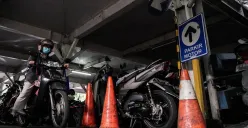 Pengendara mengeluarkan sepeda motor dari area parkir. (Sumber: Poskota/Bilal Nugraha Ginanjar)